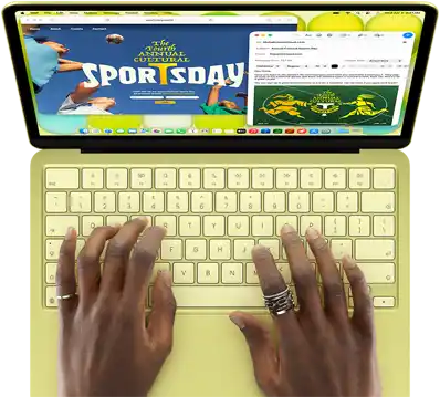 MacBook Neo, Farbe Zitrus, eine Person tippt auf der Tastatur und verfasst eine E-Mail Einladung zur Eröffnung eines Sportevents, die Website für das Event wird daneben angezeigt